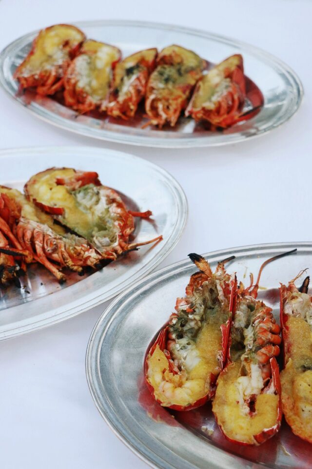 Grilled lobster halves presented on silver trays