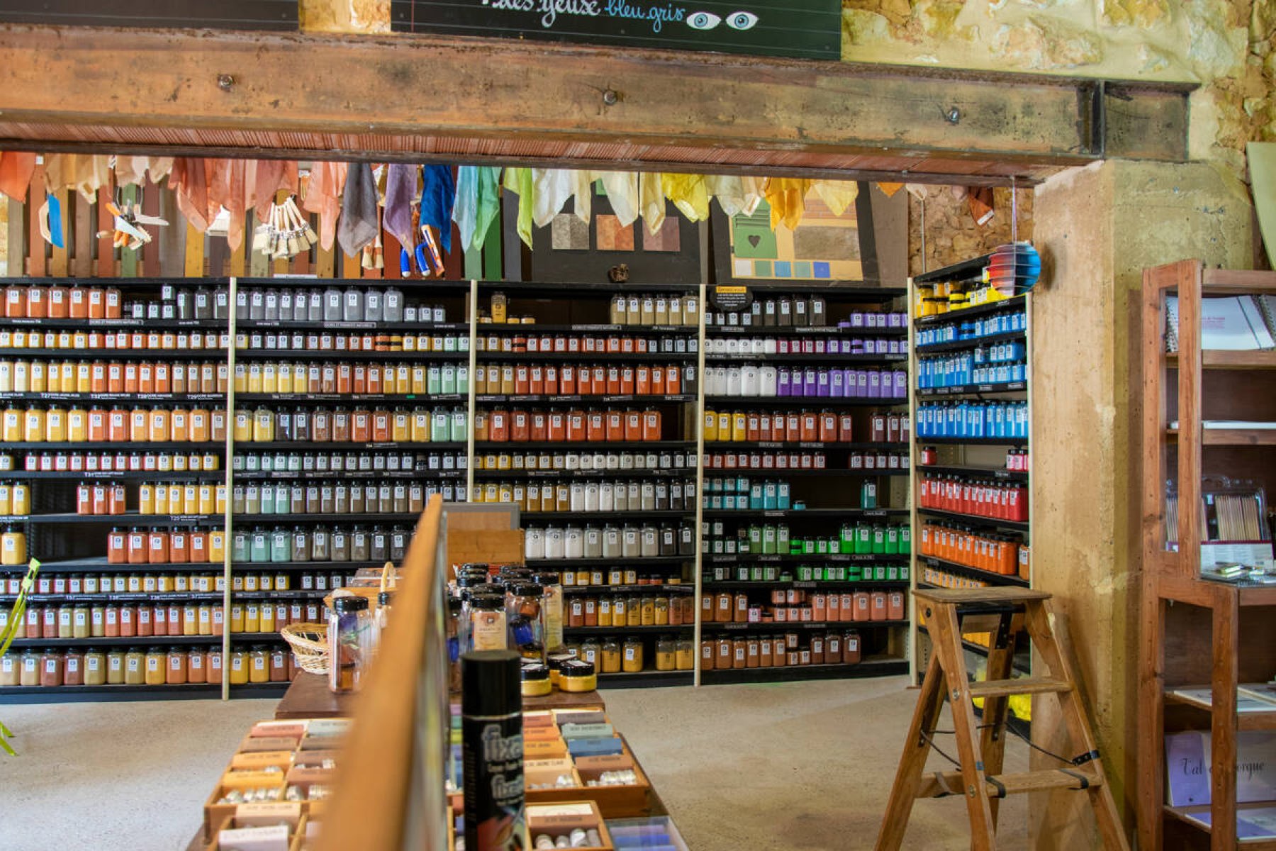 Rows of pigment jars in the Okhra ecomuseum's colour shop