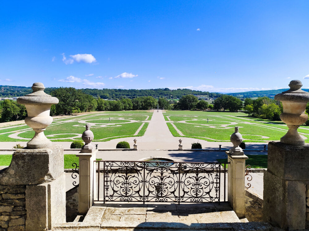 The formal gardens of the Chateau de Sauvan seen from the terrace, the alley running out to the Provencal hills
